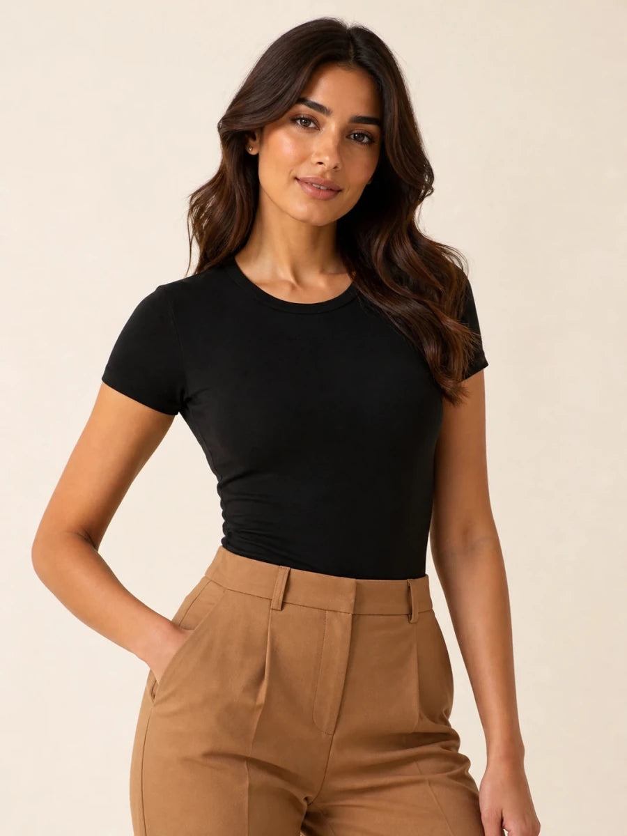 Black crew-neck short-sleeve top tucked into camel trousers, front view
