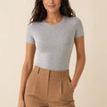 Grey crew-neck short-sleeve top tucked into camel trousers, front view