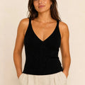 Model wearing the ELLY black ribbed knit V-neck top with a fitted sleeveless silhouette.