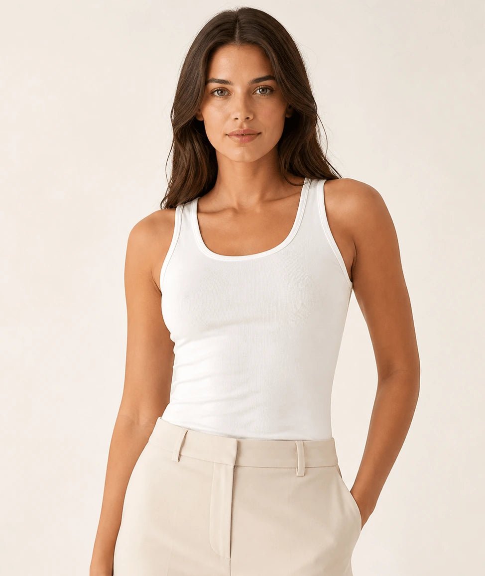 White longline tank top tucked into light tailored trousers, front view