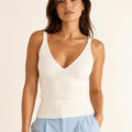Model wearing the ELLY ivory ribbed knit V-neck top with a fitted sleeveless silhouette.