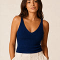 Model wearing the ELLY navy blue ribbed knit V-neck top with a fitted sleeveless silhouette.